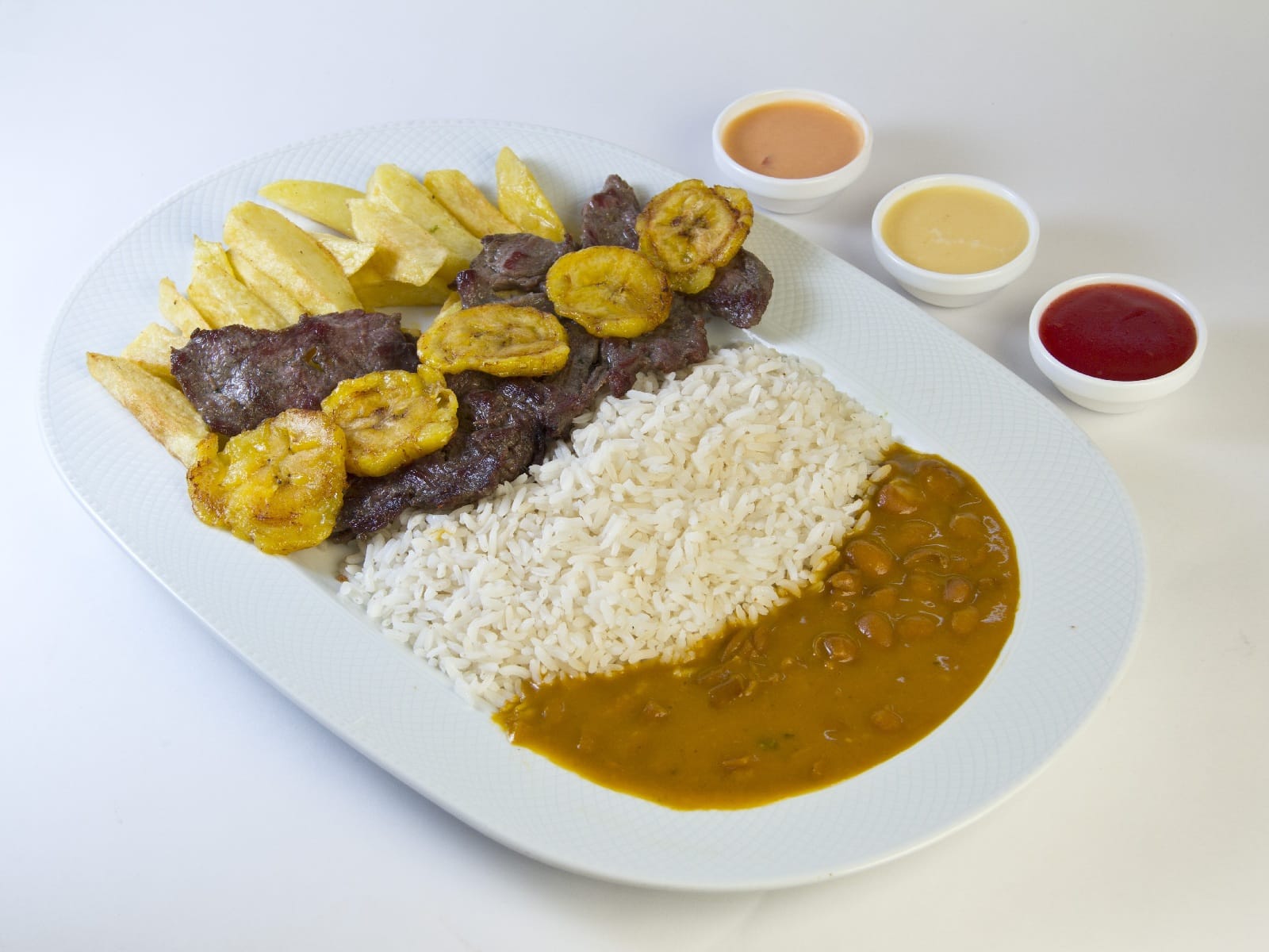 Patacones, rice and beans on a plate
