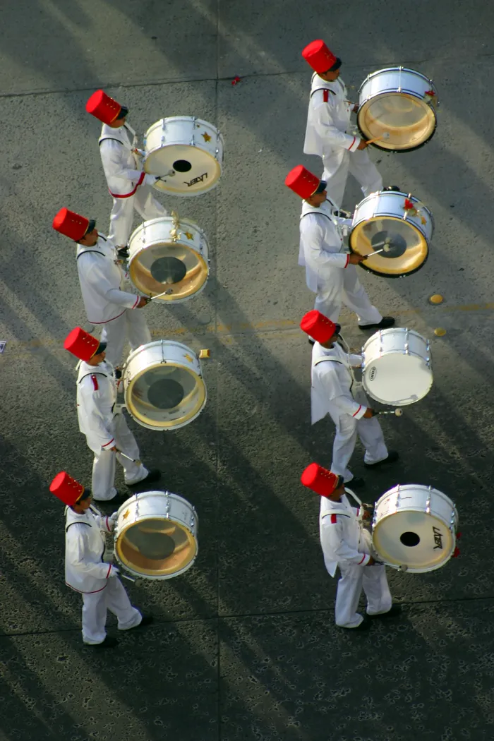 The drummers of a marching band on parade, seen from above