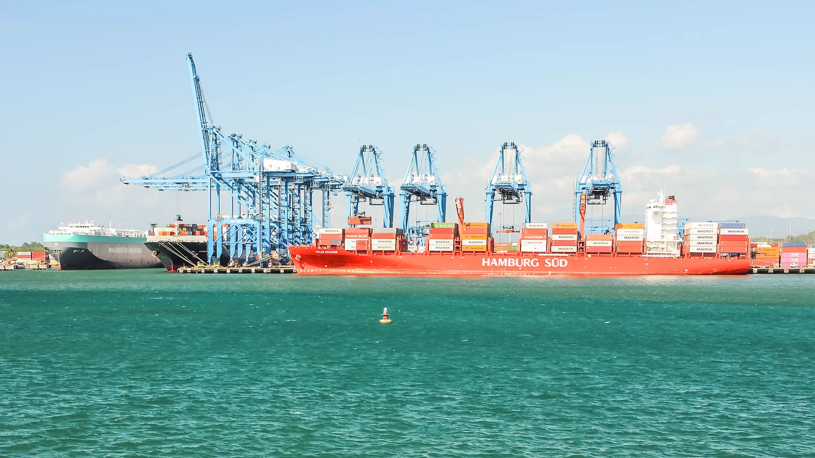 A red container ship beside the cranes of the Port of Colón on the Caribbean side of the canal